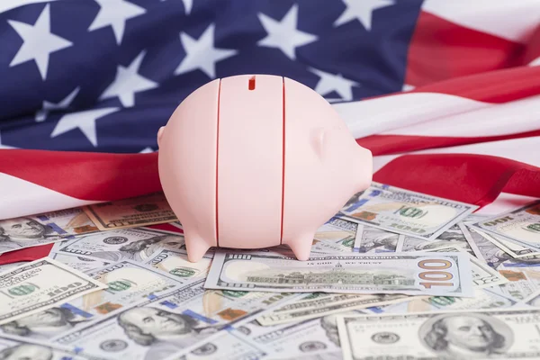 Tirelire rose sur dollars avec drapeau américain — Photo
