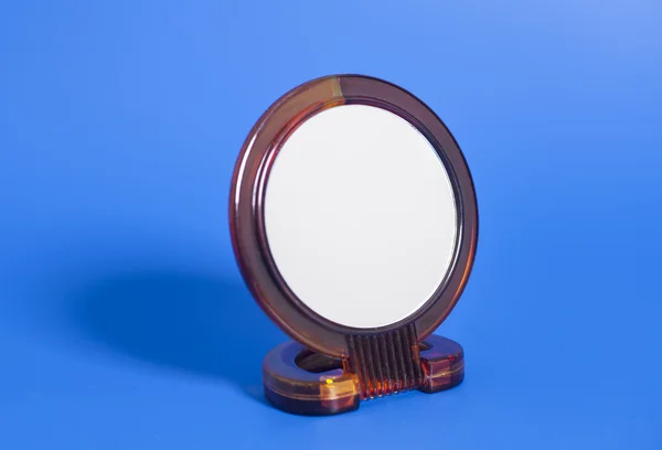 Espelho de maquiagem no fundo azul — Fotografia de Stock