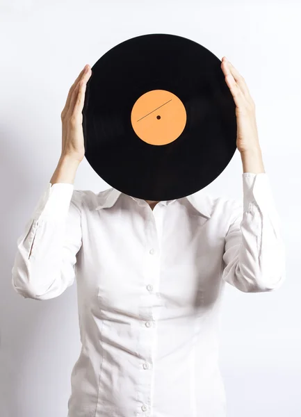 Mujer sosteniendo disco de vinilo sobre la cara —  Fotos de Stock