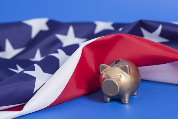 Golden Piggy Bank avec drapeau américain sur fond bleu — Photo