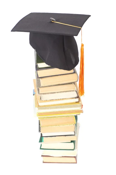 Sombrero de graduación con libros aislados en blanco — Foto de Stock