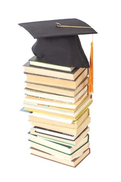 Sombrero de graduación con libros aislados en blanco — Foto de Stock