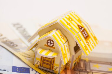 Emlak iş kavramı. Oyuncak evin model Euro yerleştirilen 