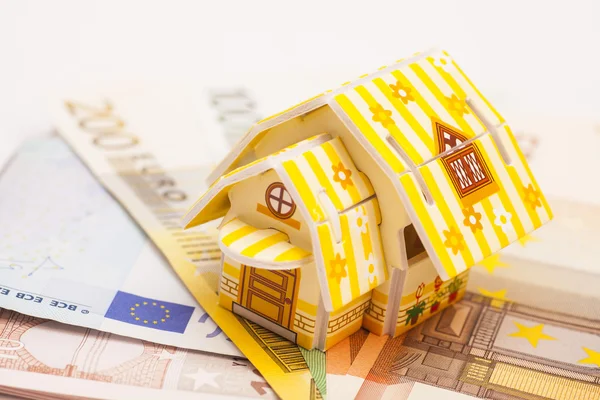 Emlak iş kavramı. Oyuncak evin model Euro yerleştirilen 