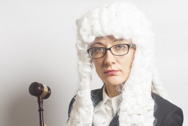 Female judge wearing  wig and  mantle with eyeglasses holding ju clipart