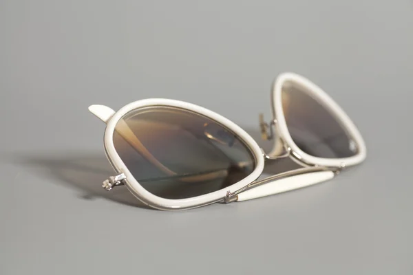 Óculos de sol brancos no fundo cinza — Fotografia de Stock