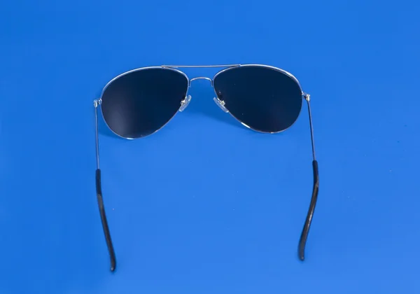 Gafas de sol sobre fondo azul —  Fotos de Stock