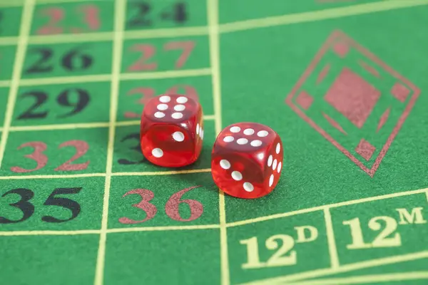 Roll of the red dice on a game table in a casino — Stock Photo, Image