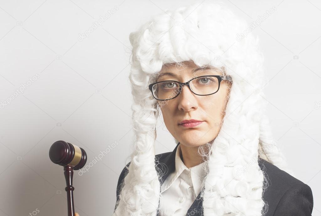Female judge wearing  wig and  mantle with eyeglasses holding ju