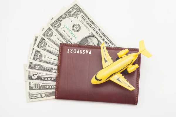 Реактивный самолет и паспорт с долларами — стоковое фото