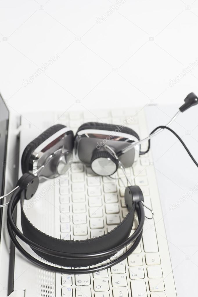 Headset on laptop computer keyboard.Communication concept