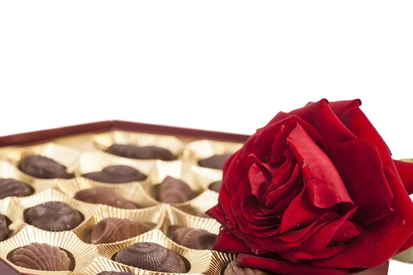 Schokoladenbox und rote Rose — Stockfoto