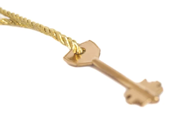Golden key hanging on gold chain isolated over white — Stock Photo, Image
