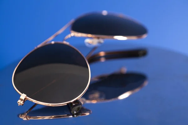 Сонцезахисні окуляри на синьому фоні — стокове фото