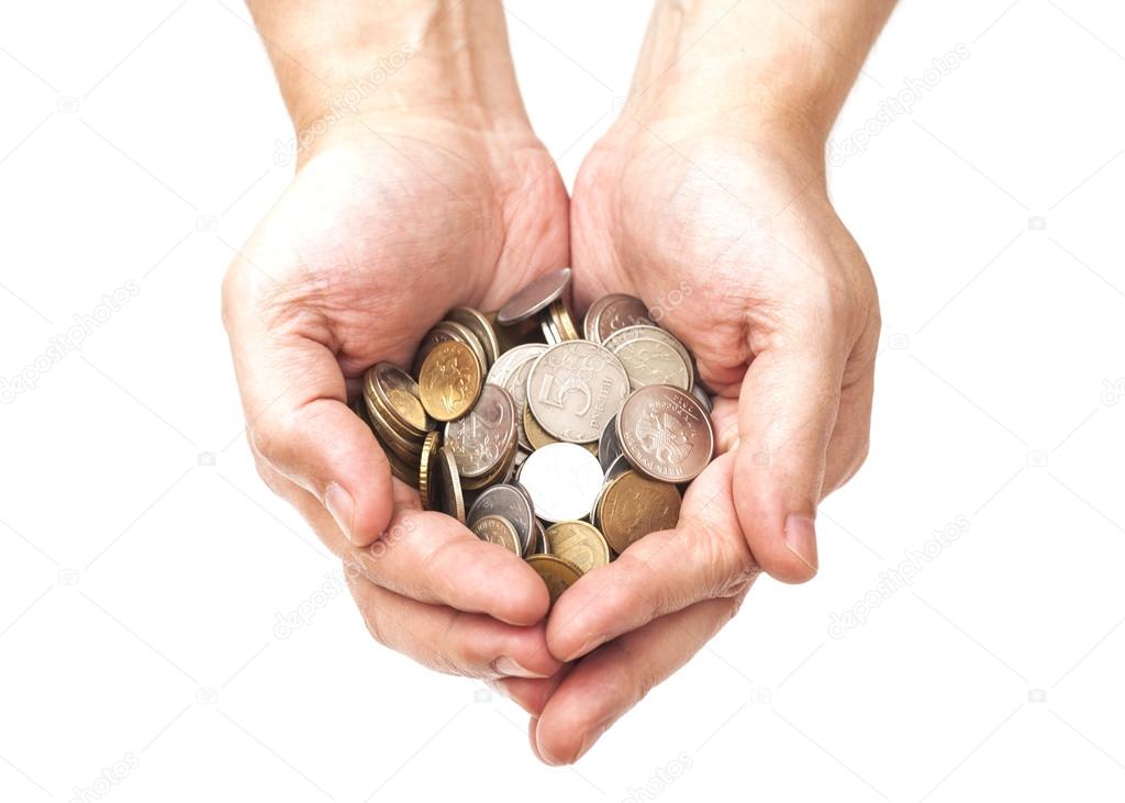 Handful of coins in palm hands isolated on white