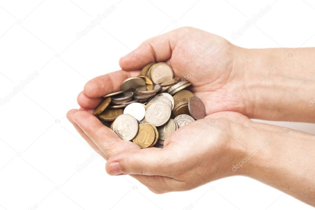 Handful of coins in palm hands isolated on white