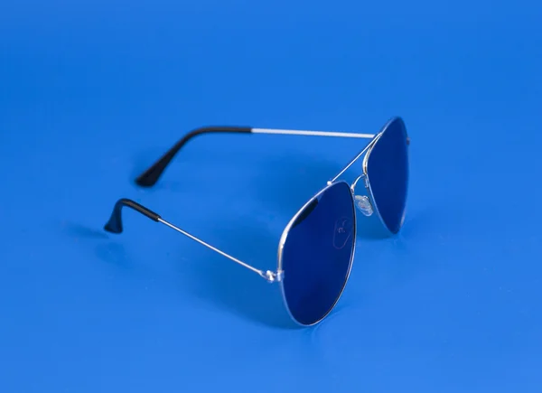 Солнечные очки на синем фоне — стоковое фото