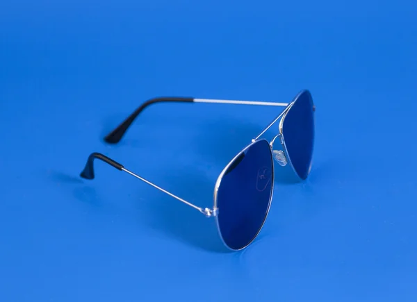 Lunettes de soleil sur fond bleu — Photo