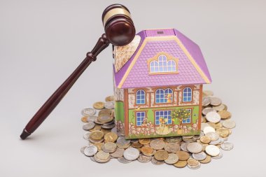 Home, coins and gavel isolated on gray.Real estate concept  clipart