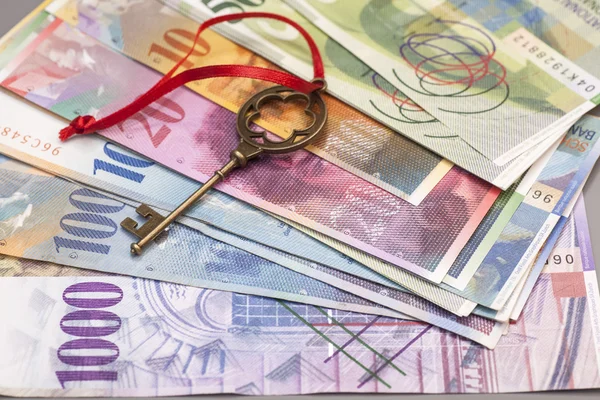 Clave para el éxito con arco rojo en billetes de franco suizo — Foto de Stock
