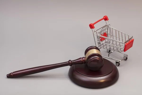 Gri arka plan üzerinde alışveriş sepeti ile Adalet tokmak