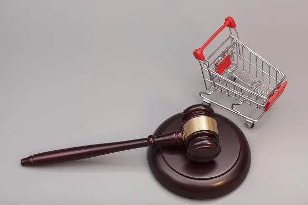 Gri arka plan üzerinde alışveriş sepeti ile Adalet tokmak
