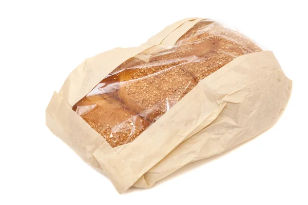 Pão branco com gergelim em um saco de papel isolado no backgro branco — Fotografia de Stock