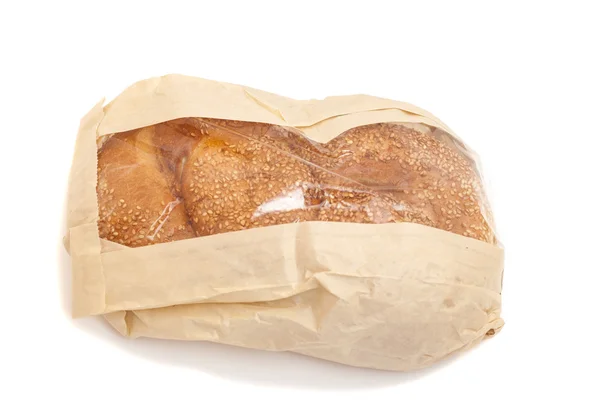 Biały chleb z sezamem w papierowej torebce na białym tle na biały backgro — Zdjęcie stockowe