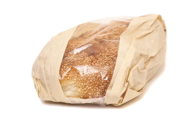 Weißbrot mit Sesam in einer Papiertüte isoliert auf weißem Backblech — Stockfoto