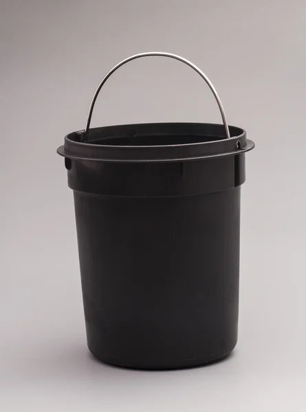 Black plastic bucket isolated on gray background — Stock Photo, Image