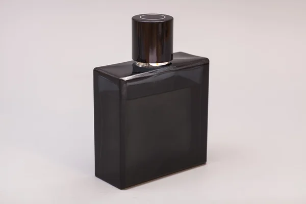 Perfumy męskie w butelce na białym tle na szarym tle — Zdjęcie stockowe