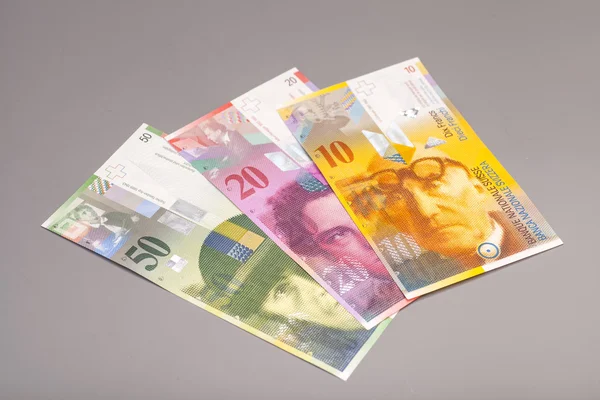 Franków szwajcarskich, waluta Szwajcarii na szarym tle — Zdjęcie stockowe