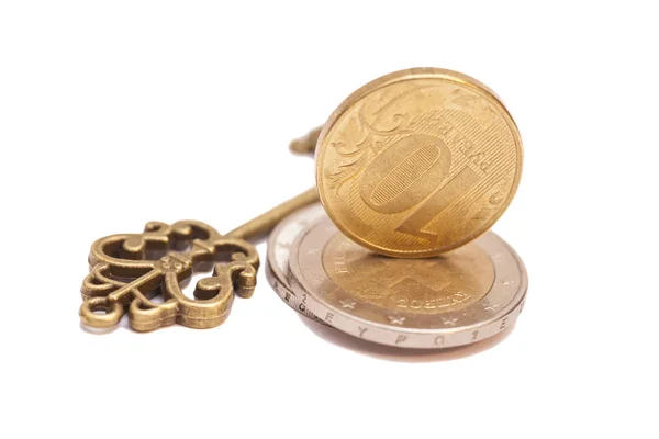Chave para o sucesso e moedas isoladas em branco — Fotografia de Stock