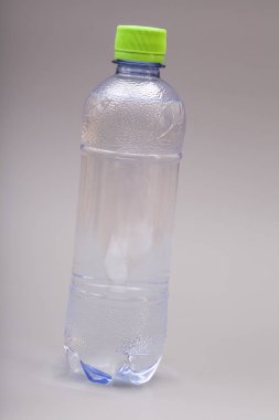 Gri arkaplanda su şişesi