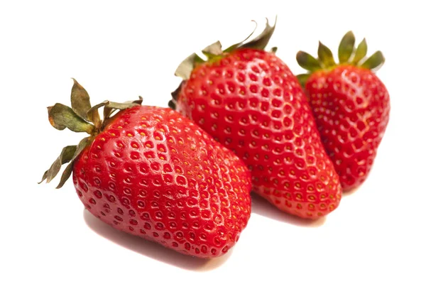 Tres fresas maduras con hojas sobre fondo blanco — Foto de Stock