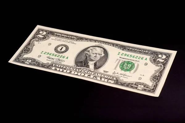 Dois dólares em fundo preto — Fotografia de Stock