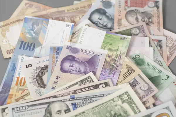Monedas internacionales aisladas sobre fondo gris — Foto de Stock