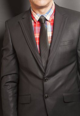 Adam siyah takım elbise ve siyah bir zemin üzerine siyah kravat