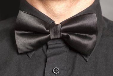 Adam siyah yay ile siyah gömlek giymiş