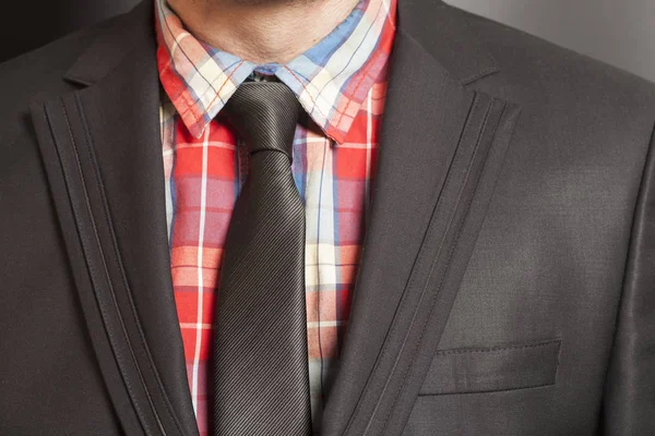 Man in zwart pak en zwarte stropdas op een zwarte achtergrond — Stockfoto