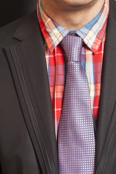 Hombre en traje negro y corbata sobre fondo negro —  Fotos de Stock