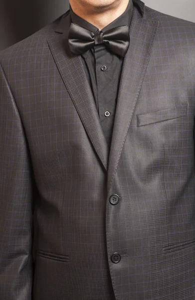 Mies Checkered puku ja musta ja musta rusetti harmaa backgr — kuvapankkivalokuva