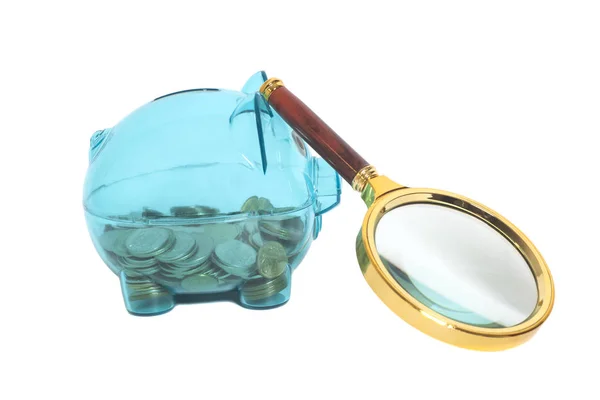 Kaca Piggy bank dengan koin dan kaca pembesar — Stok Foto