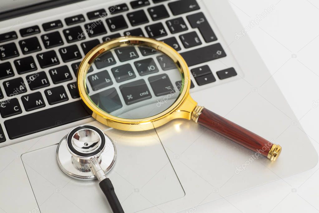 Laptop With Magnifying Glass And Stethoscope