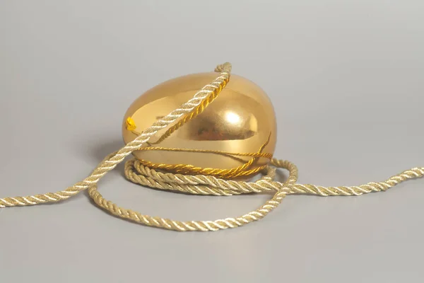Œuf doré avec corde dorée — Photo
