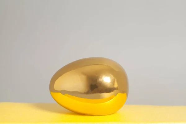 Huevo dorado sobre fondo gris —  Fotos de Stock