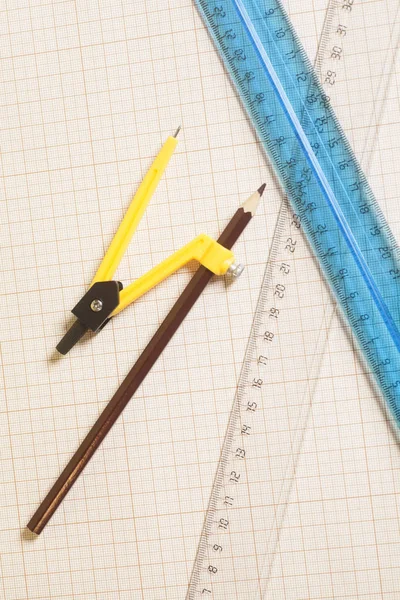Bussola di disegno giallo con pensil nero e righelli sul grafico pa — Foto Stock