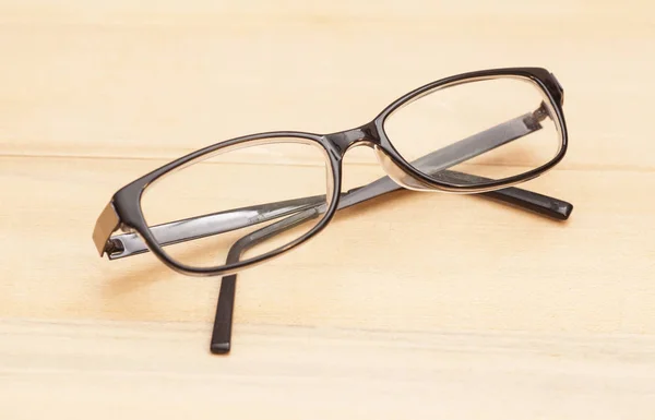 Brýle na dřevěný stůl — Stock fotografie