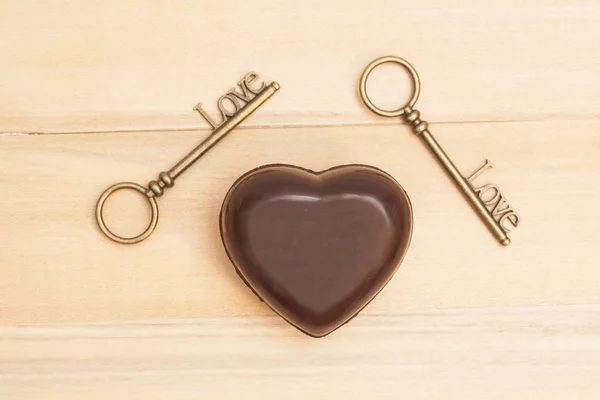 Herz und Schlüssel für die Liebe auf Holzgrund — Stockfoto