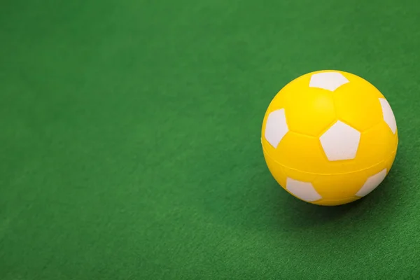Κίτρινη μπάλα ποδοσφαίρου στο πράσινο πεδίο — Φωτογραφία Αρχείου